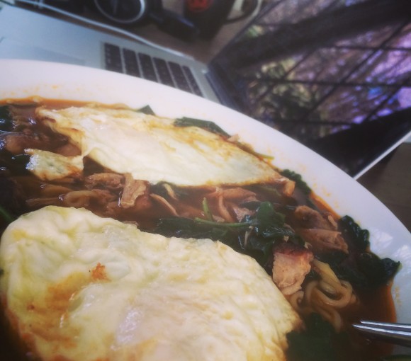 Ramen noodles with baby kale, smoked meat, and fried eggs.